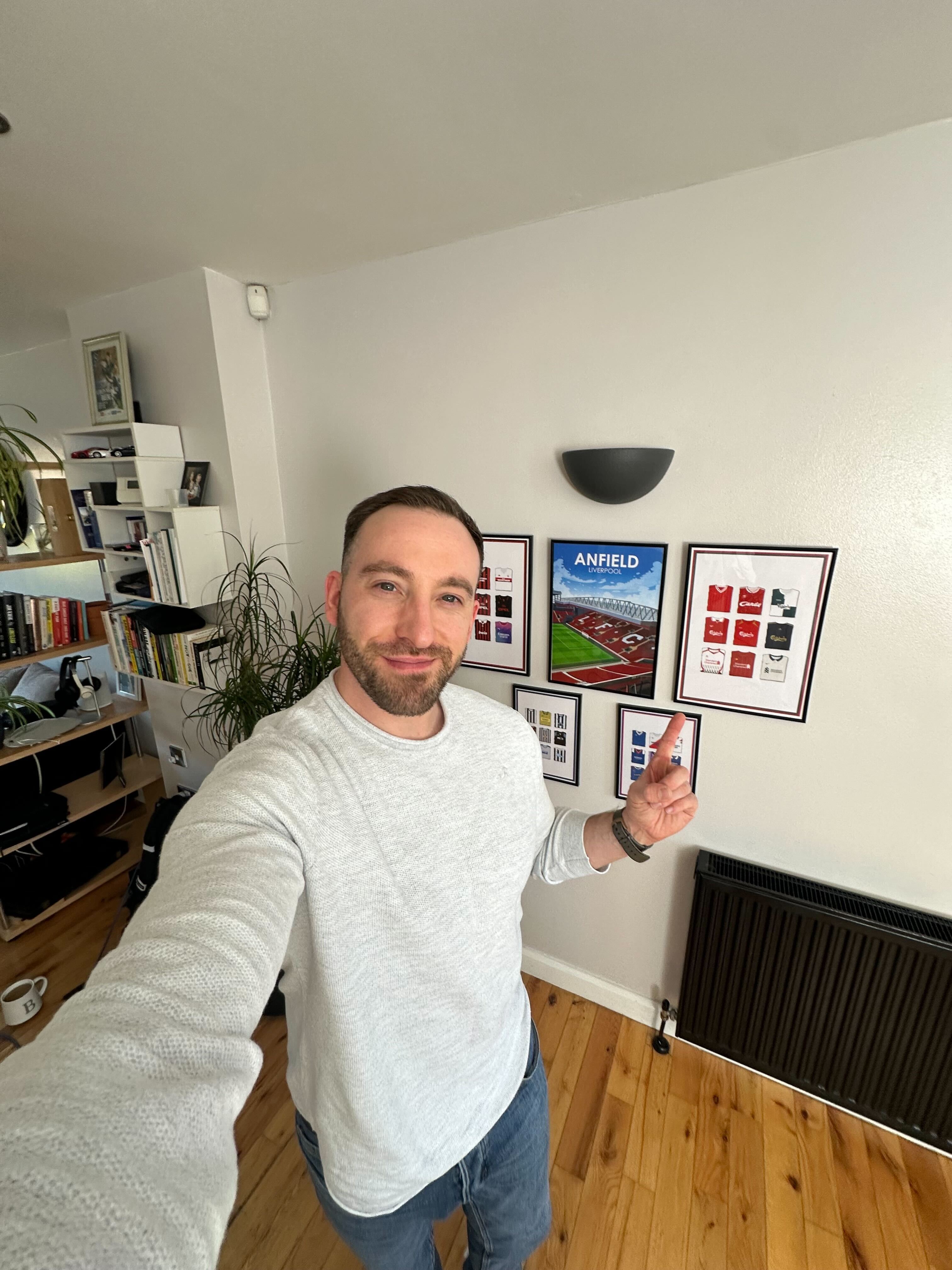 Gallery wall of framed football kit history prints in a home
