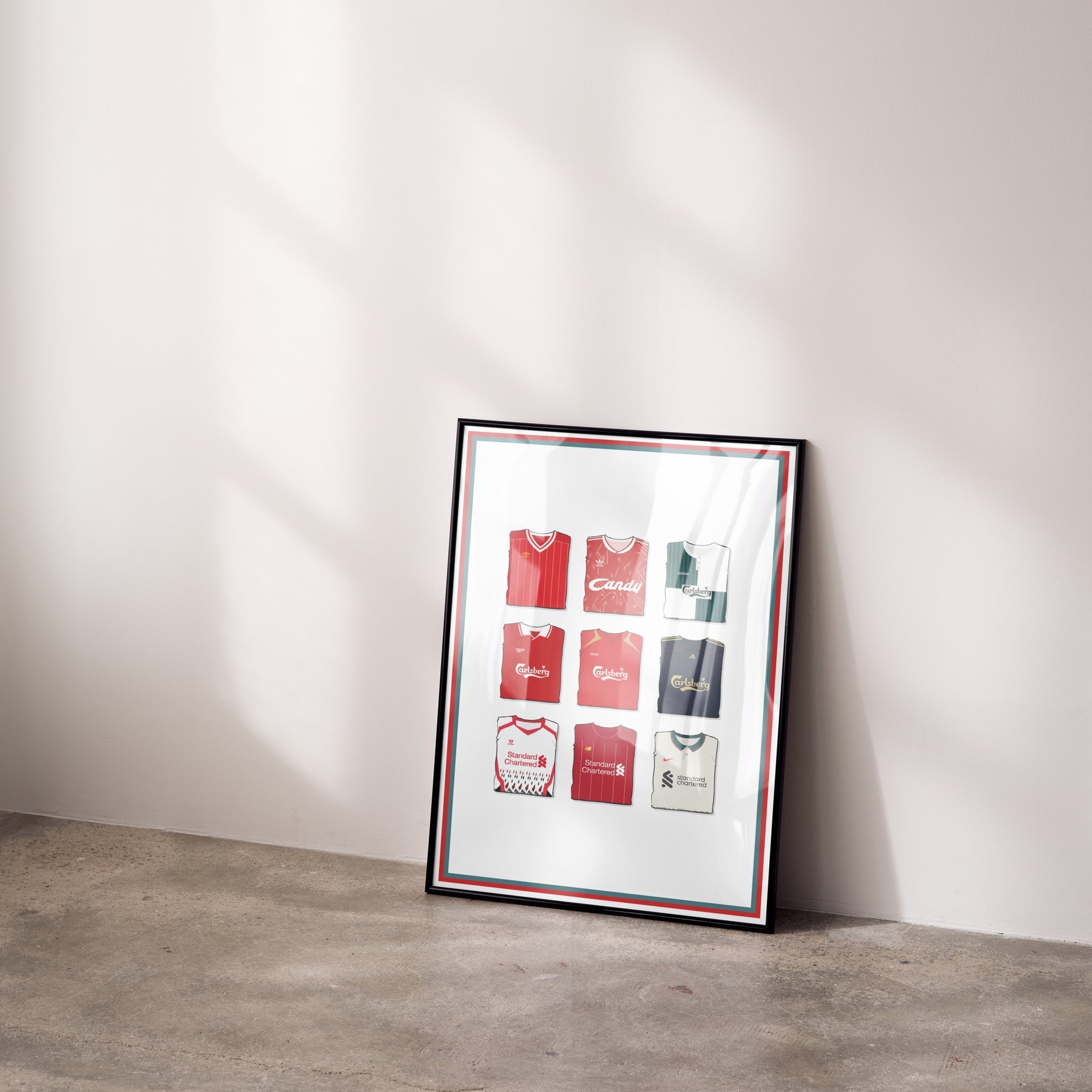 Framed Liverpool kit history print leaning against wall